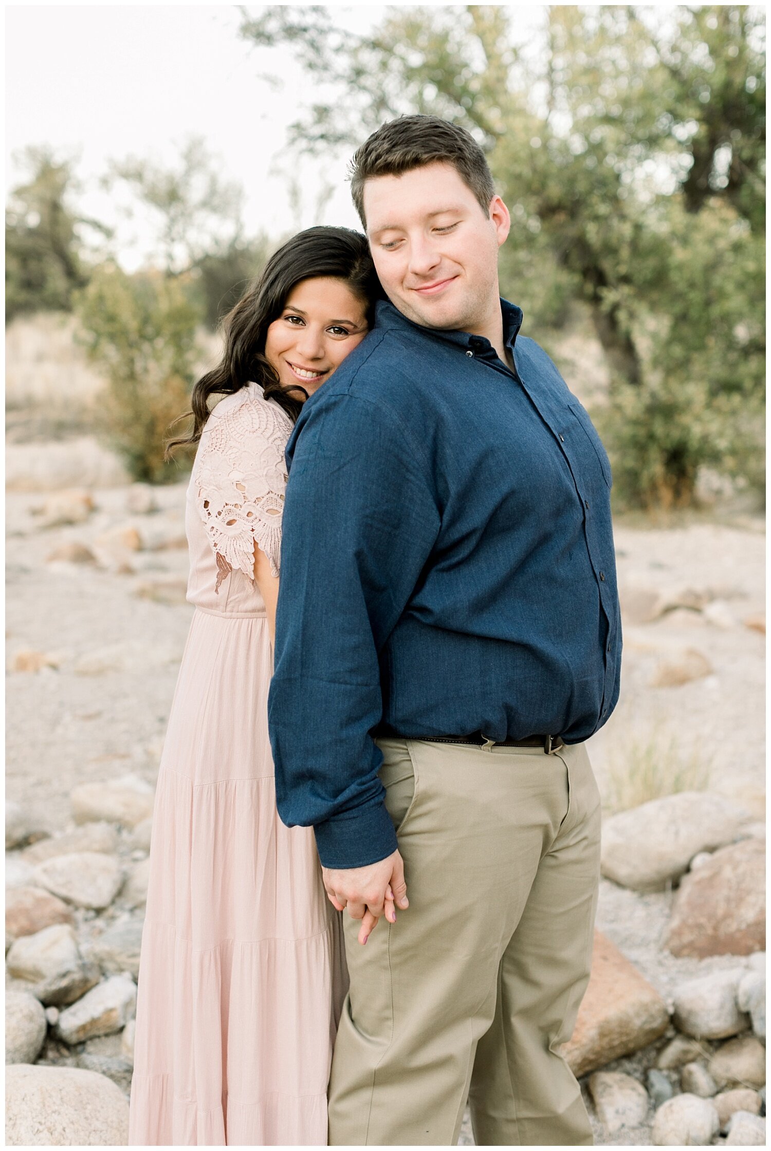 Couple wears a pink dress and blue button down shirt during their desert engagement session in Tucson, Arizona.