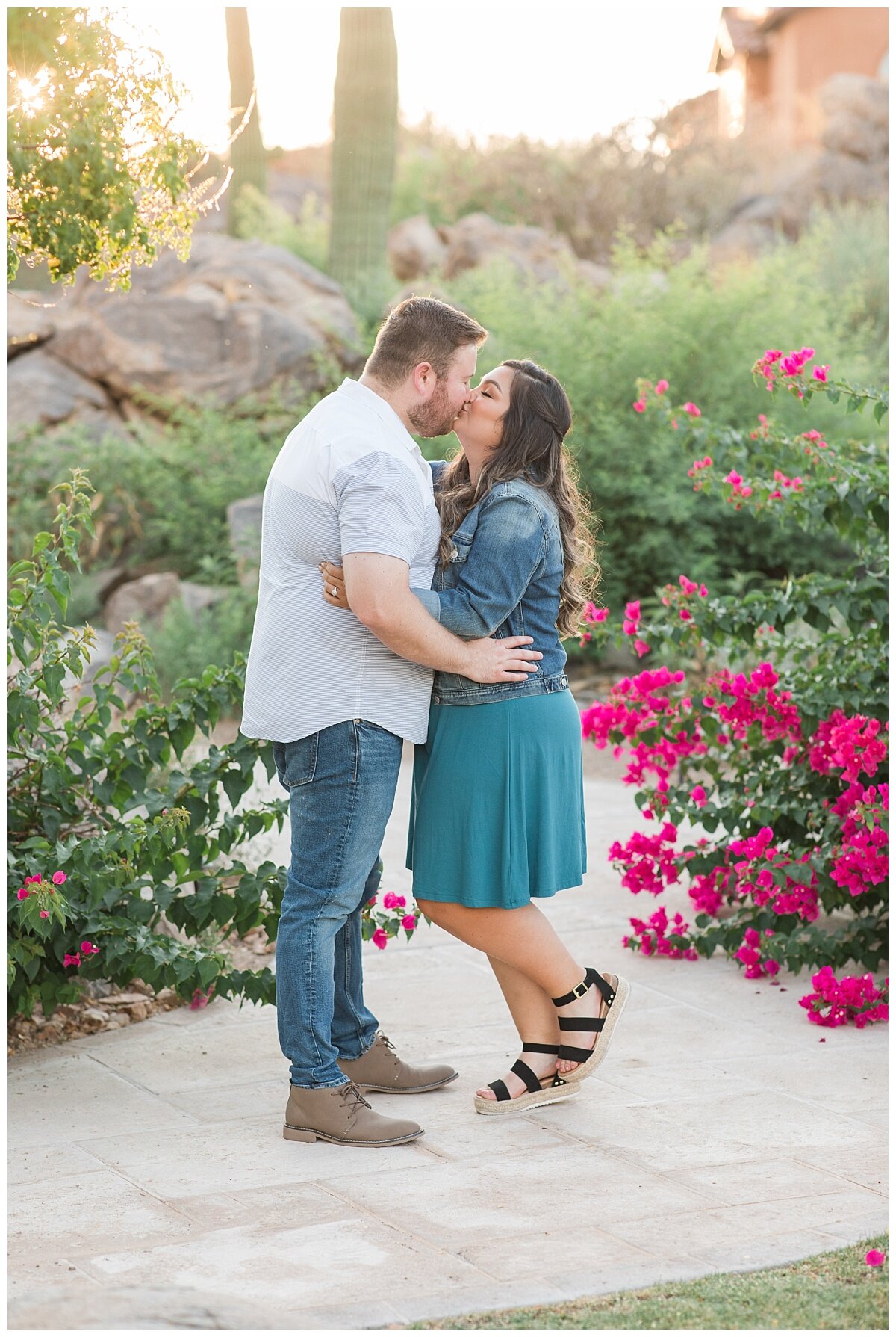 Engagement Picture of couple kissing surrounded by bouganvilla and saguaros