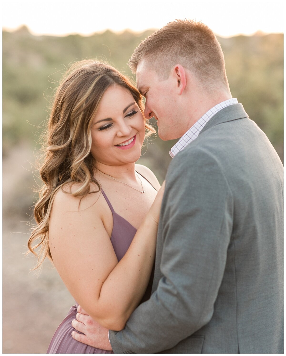 Tucson desert trail, Honey Bee Canyon, is the perfect location for your Engagement Session. Bride to be is wearing a sleeveless lilac dress at her engagement session from Lulus. Groom to be wearing a grey suit jacket from Banana Republic. Photos tak…