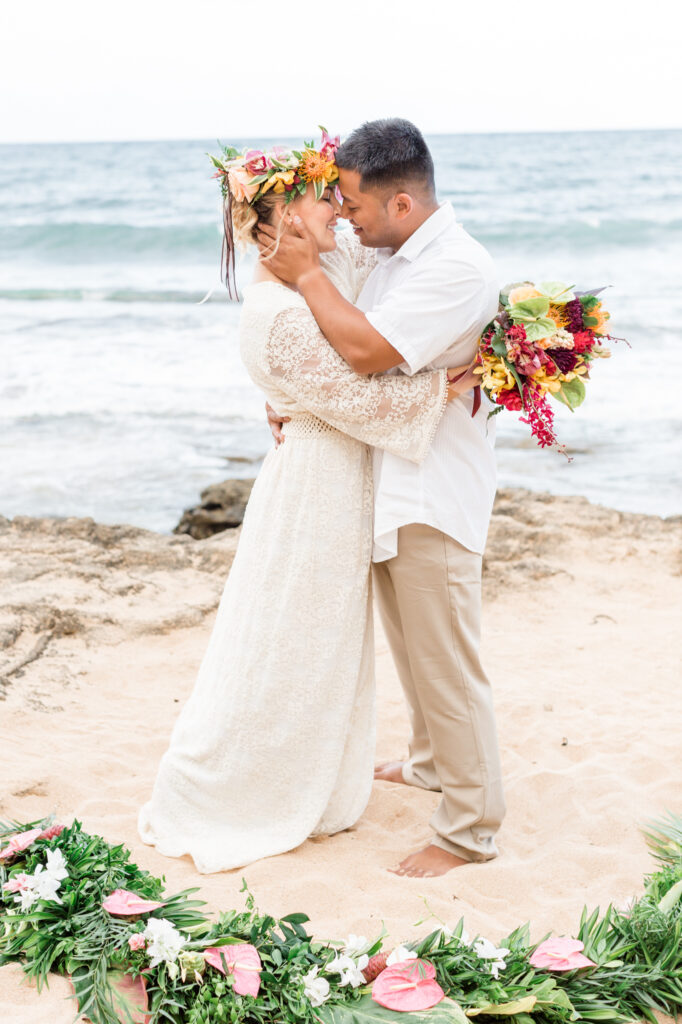 Couple shares their first kiss after their beach wedding in Kauai