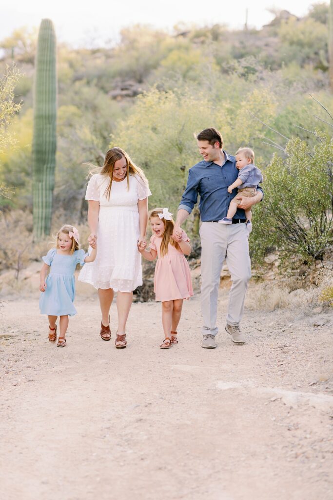 Tucson Fall Mini Session Family Photo. Captures Family of five walking in the desert laughing and enjoying their time as a family.