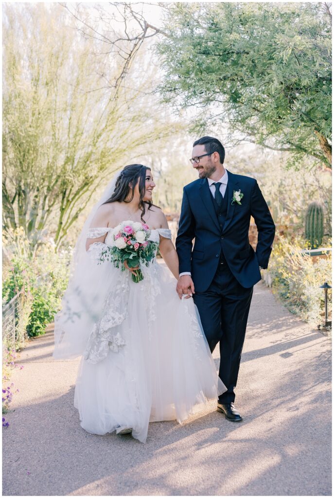 Bride and Groom walk hand in hand on their wedding day at the Tucson Botanical Gardens.